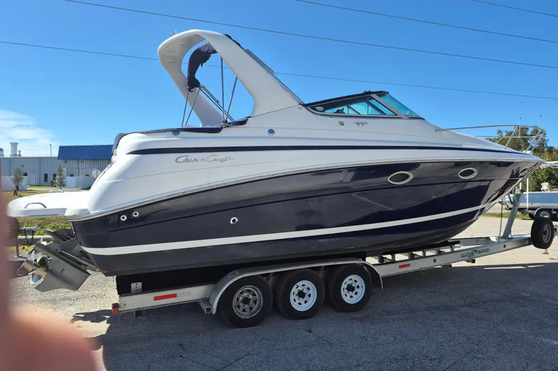 Slide: The Image of 2003 Chris-Craft 328 Express Cruiser on trailer, blue and white design, sunny day. - 3