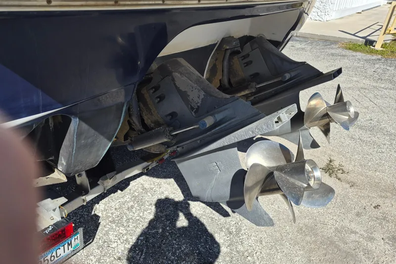 Slide: The Image of 2003 Chris-Craft 328 Express Cruiser dual propellers on a trailer, close-up view. - 4