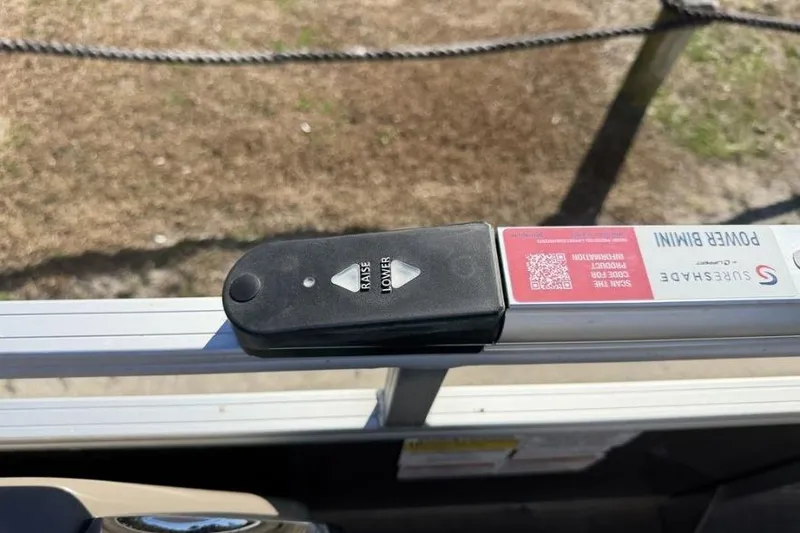 Slide: The Image of 2023 Sun Tracker Party Barge 20 DLX interior seating with beige upholstery and cup holders. - 11