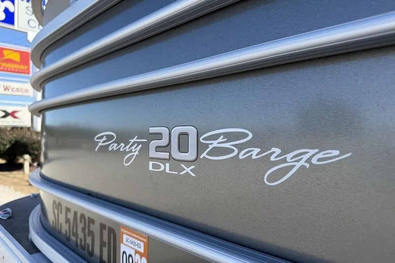 Slide: The Image of 2023 Sun Tracker Party Barge 20 DLX pontoon boat close-up with logo and registration. - 20