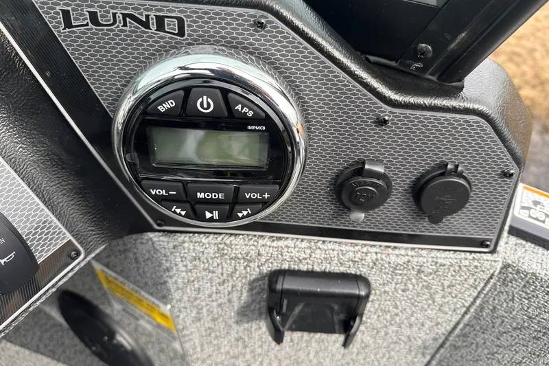 Slide: The Image of Control panel of 2026 Lund 1775 Adventure Sport boat with audio system and power outlets. - 17