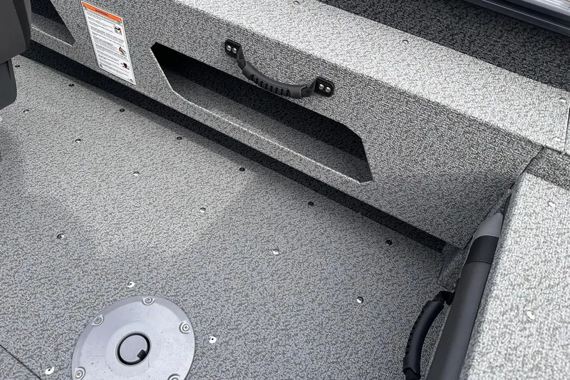 Slide: The Image of Interior of 2026 Lund 1775 Adventure Sport boat, featuring textured flooring and storage compartment. - 23