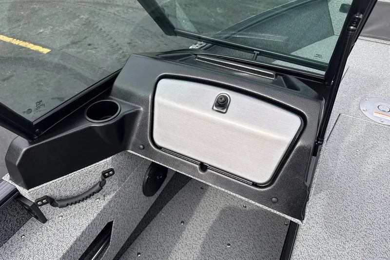 Slide: The Image of 2026 Lund 1775 Adventure Sport boat dashboard with cup holder and storage compartment. - 24