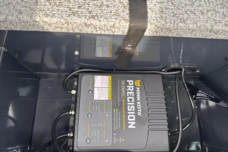Slide: The Image of Minn Kota Precision battery charger in 2026 Lund 1775 Adventure Sport boat compartment. - 27