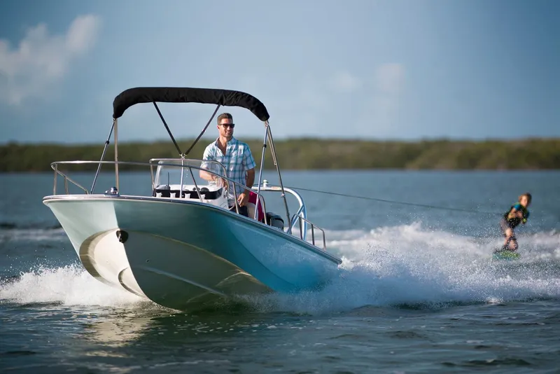 Slide: The Image of Manufacturer Provided Image: 2026 Boston Whaler 170 Montauk boat towing a wakeboarder on a sunny day. - 4
