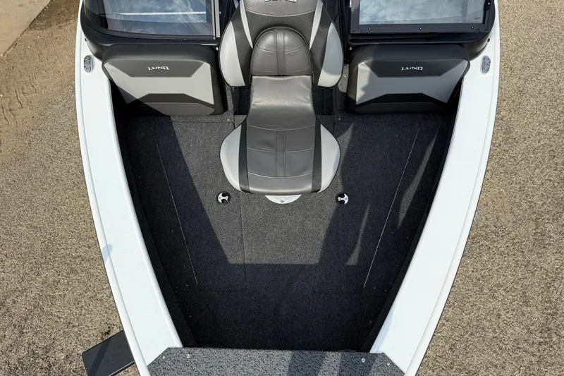 Slide: The Image of 2026 Lund 1875 Crossover XS boat interior with gray seating and carpeted floor. - 11