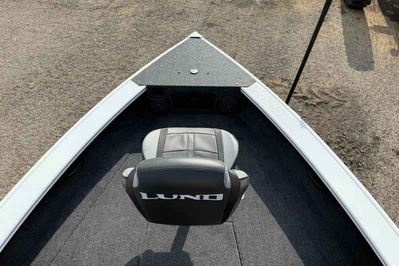 Slide: The Image of 2026 Lund 1875 Crossover XS boat interior with a single seat and carpeted deck. - 13