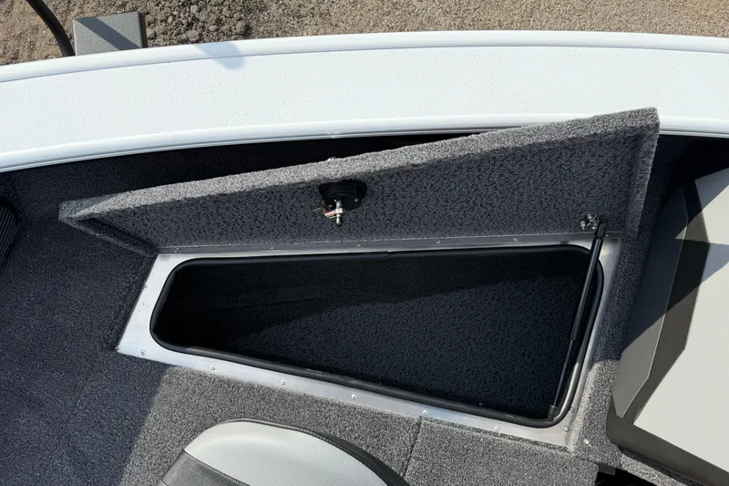 Slide: The Image of 2026 Lund 1875 Crossover XS boat storage compartment with open lid, showcasing interior space. - 15