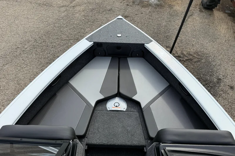 Slide: The Image of 2026 Lund 1875 Crossover XS boat interior with gray seating and storage compartments. - 17