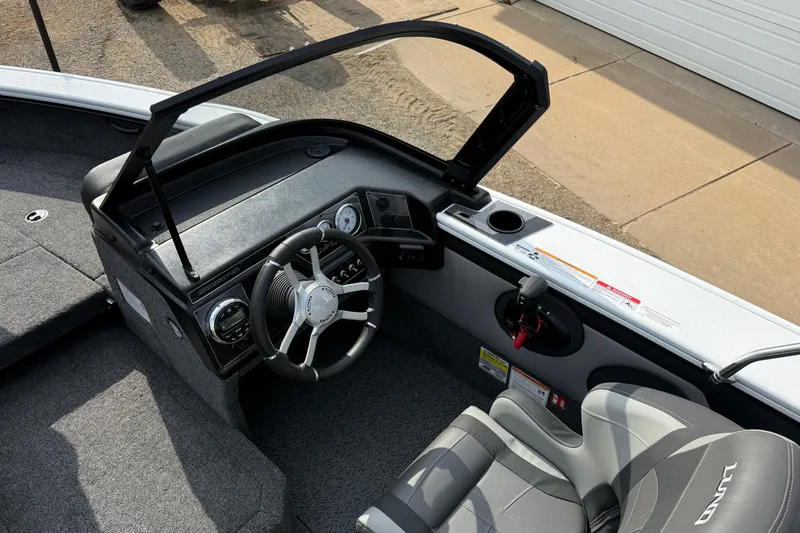 Slide: The Image of 2026 Lund 1875 Crossover XS boat interior with steering wheel and seating. - 21