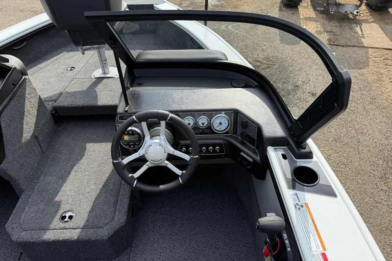 Slide: The Image of 2026 Lund 1875 Crossover XS boat interior with steering wheel and dashboard controls. - 22