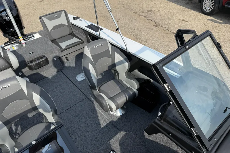 Slide: The Image of 2026 Lund 1875 Crossover XS boat interior with gray seating and open windshield. - 23