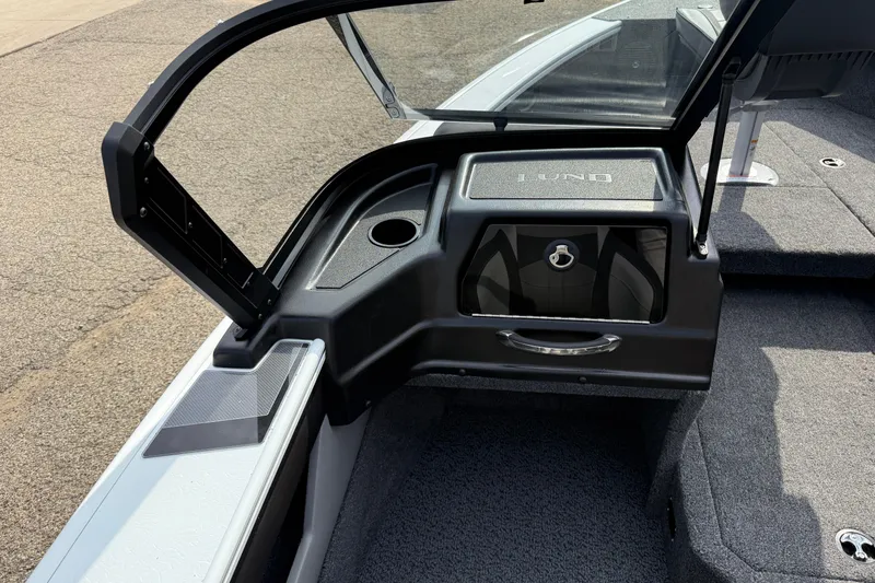 Slide: The Image of 2026 Lund 1875 Crossover XS boat interior with open windshield and storage compartment. - 25