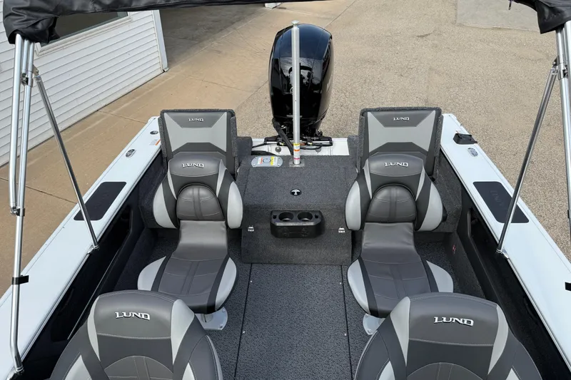 Slide: The Image of 2026 Lund 1875 Crossover XS boat interior with gray seating and motor. - 27