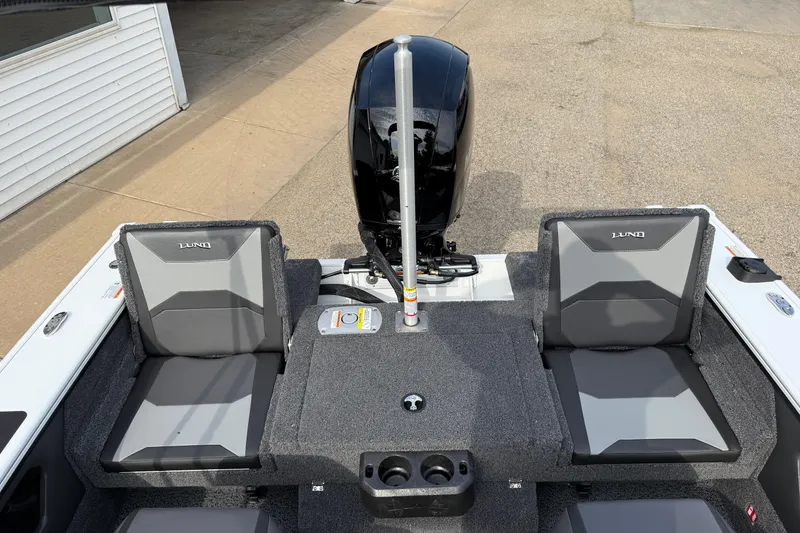 Slide: The Image of 2026 Lund 1875 Crossover XS boat interior with seating and motor view. - 30