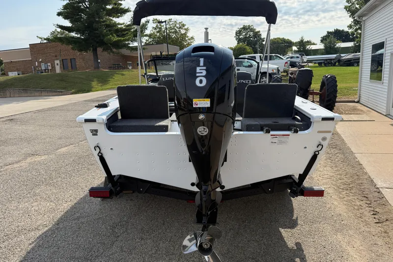 Slide: The Image of 2026 Lund 1875 Crossover XS boat with 150 HP engine, parked outdoors. - 6