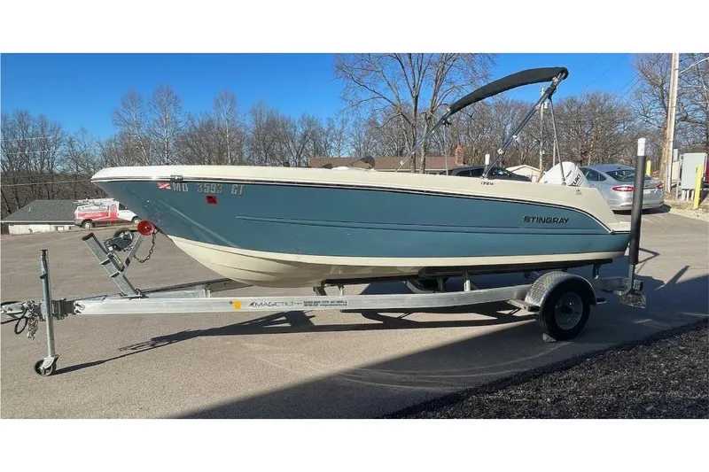 Slide: The Image of 2021 Stingray 172 SC boat on trailer, parked outdoors on a sunny day. - 2