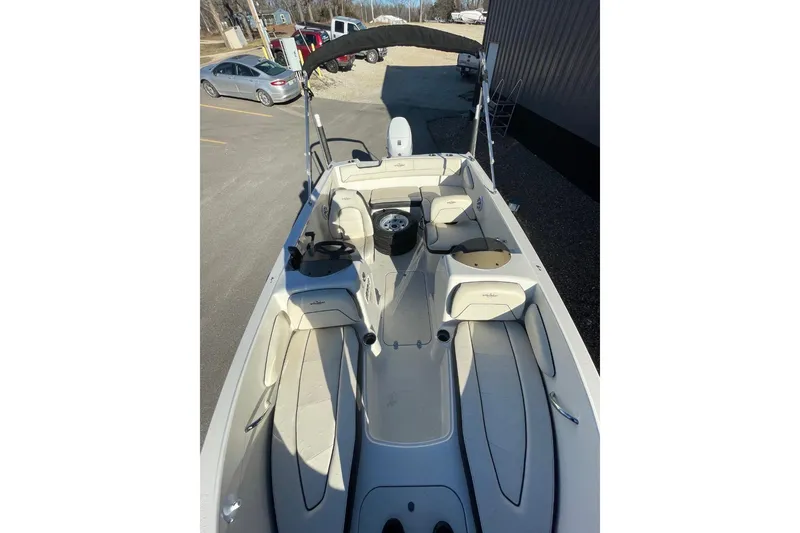 Slide: The Image of 2021 Stingray 172 SC boat interior with seating and steering wheel, parked outdoors. - 8