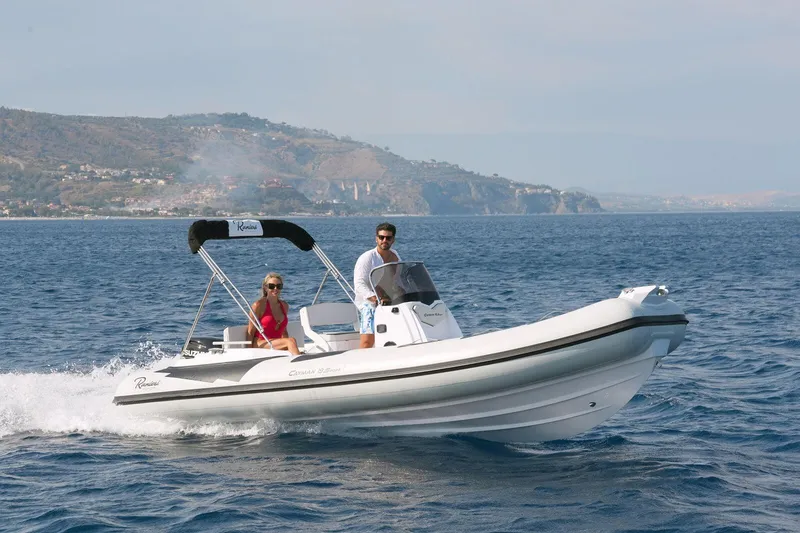 Slide: The Image of 2026 Ranieri CAYMAN 19 Sport boat cruising on open water with scenic coastline backdrop. - 4