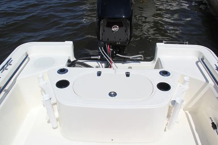 Slide: The Image of Manufacturer Provided Image: 2026 Boston Whaler 150 Montauk boat interior with motor and fishing rod holders. - 12