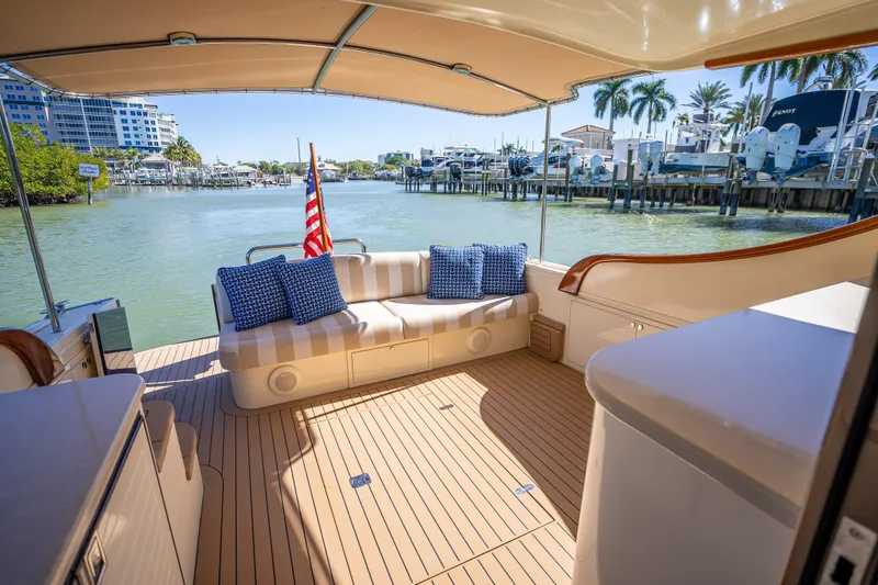 Slide: The Image of 2017 Palm Beach Motor Yachts PB45 interior with seating, dock view, and American flag. - 13