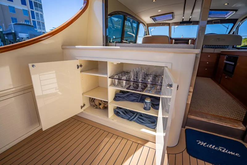 Slide: The Image of 2017 Palm Beach Motor Yachts PB45 interior with open cabinet, glassware, and ropes. - 15