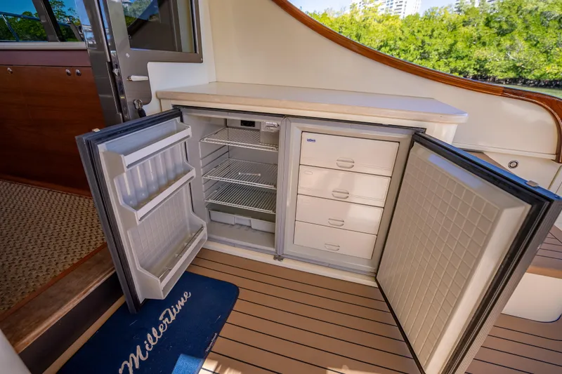 Slide: The Image of 2017 Palm Beach Motor Yachts PB45 interior with open refrigerator and storage drawers. - 16