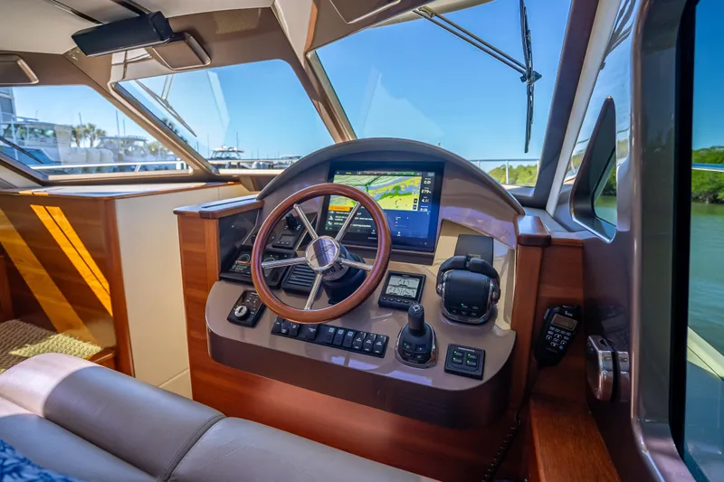 Slide: The Image of 2017 Palm Beach Motor Yachts PB45 helm with modern navigation controls and wooden accents. - 32