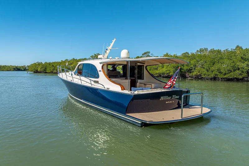 Slide: The Image of 2017 Palm Beach Motor Yachts PB45 cruising on a serene waterway under clear blue skies. - 6