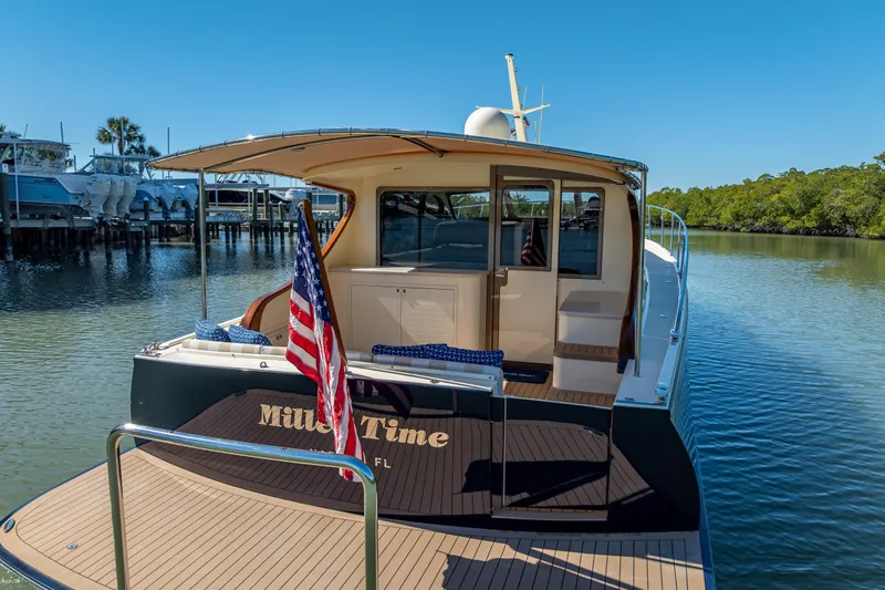 Slide: The Image of 2017 Palm Beach Motor Yachts PB45 docked, featuring elegant design and American flag. - 7