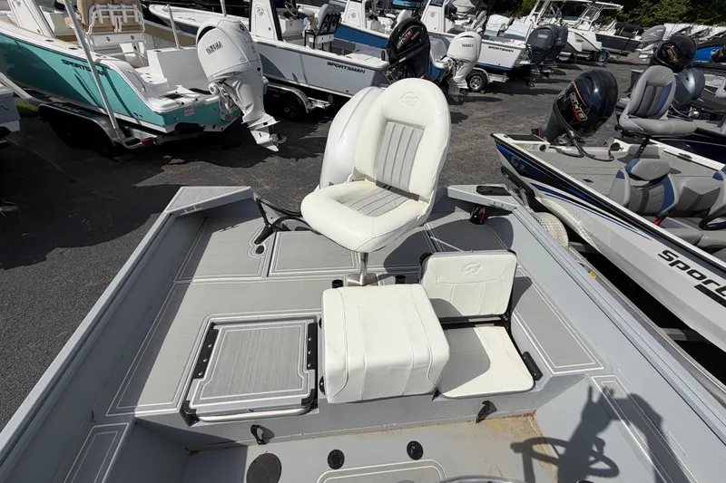 Slide: The Image of 2026 G3 Bay 20 boat deck with white swivel seat, parked on pavement. - 9