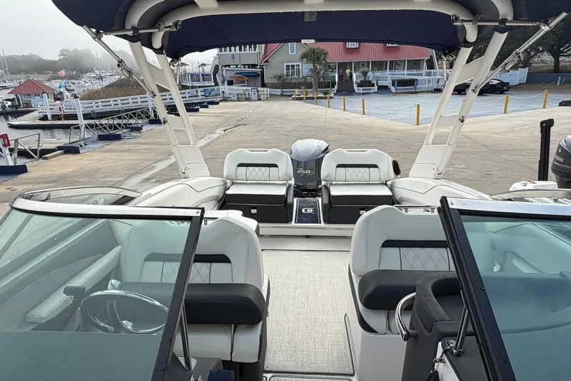 Slide: The Image of 2023 Regal LX4 boat interior with seating and steering wheel at a marina. - 12