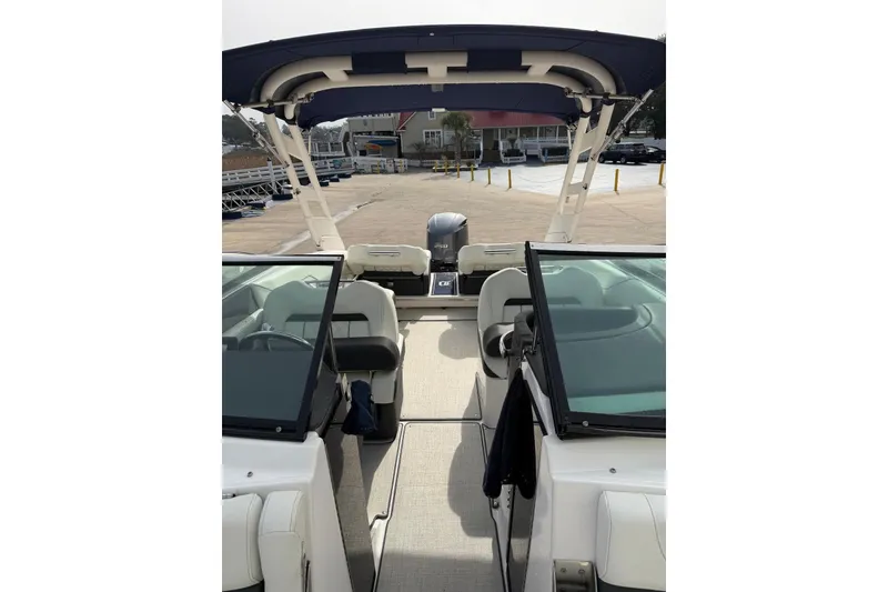 Slide: The Image of 2023 Regal LX4 boat interior with seating and canopy, docked at marina. - 14