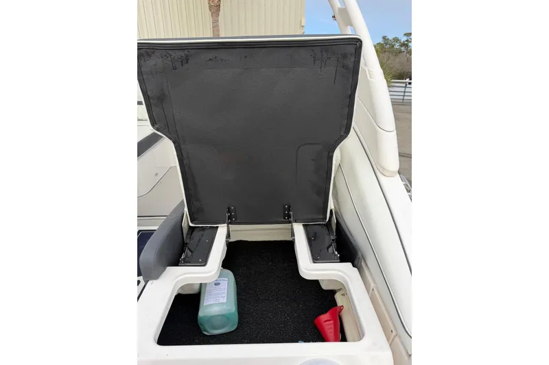 Slide: The Image of 2023 Regal LX4 boat storage compartment with cleaning supplies. - 23