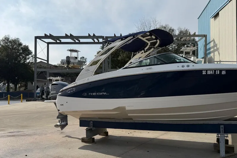 Slide: The Image of 2023 Regal LX4 boat on display at a marina with clear skies. - 3