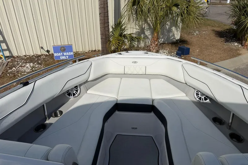 Slide: The Image of 2023 Regal LX4 boat interior with white seating, cup holders, and speakers at a boat wash area. - 6
