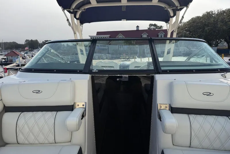 Slide: The Image of 2023 Regal LX4 boat interior with white seating and windshield at a marina. - 7