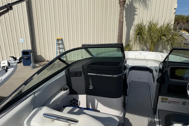 Slide: The Image of 2023 Regal LX4 boat interior with modern seating and dashboard, parked outdoors. - 8