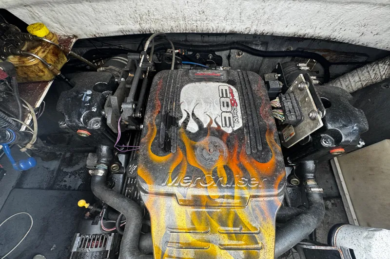 Slide: The Image of Engine of a 2008 Splendor 240 Sunstar boat with flame design on cover. - 12