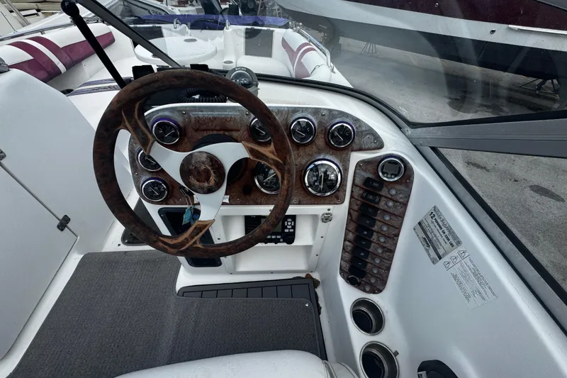 Slide: The Image of Steering console of a 2008 Splendor 240 Sunstar boat with wood accents and gauges. - 5