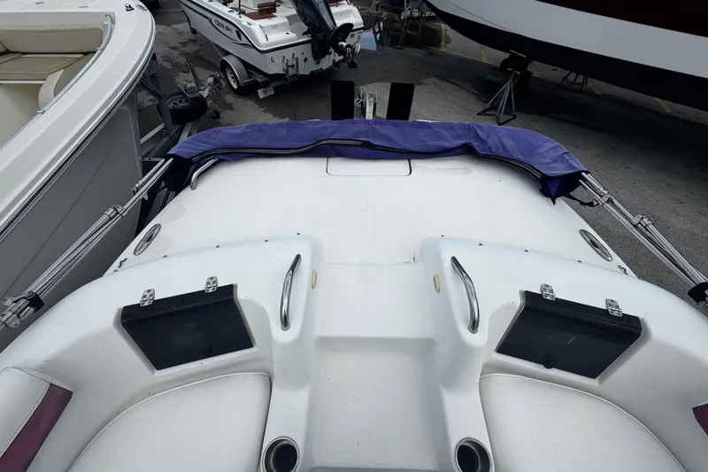 Slide: The Image of 2008 Splendor 240 Sunstar boat docked, featuring a covered deck and adjacent vessels. - 7