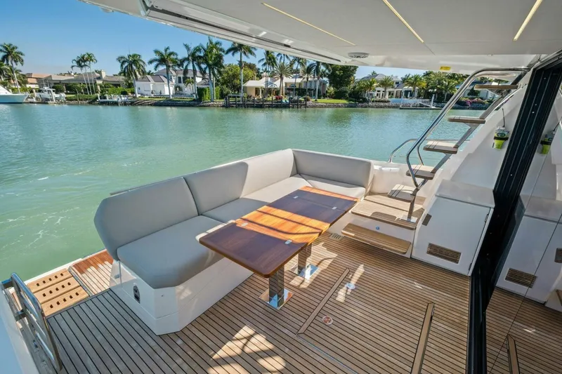 Slide: The Image of Luxurious 2022 Prestige 520 yacht deck with seating, table, and scenic waterfront view. - 47