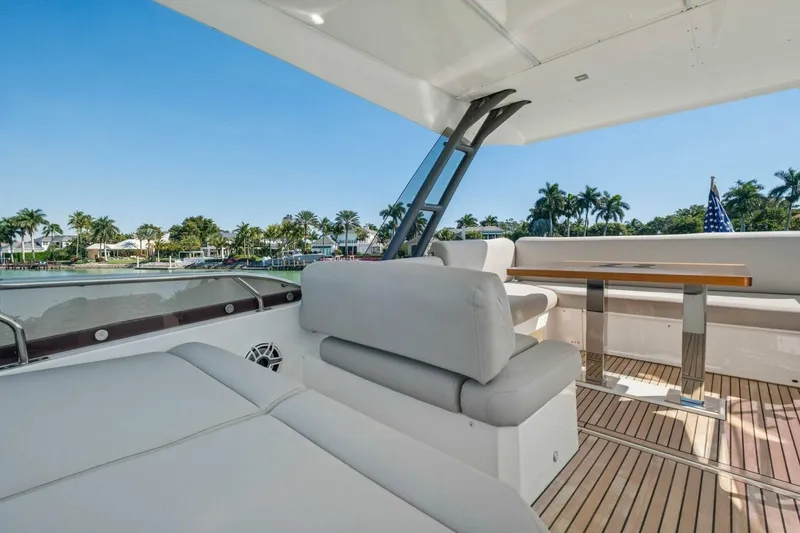 Slide: The Image of Luxurious 2022 Prestige 520 yacht deck with seating, table, and scenic waterfront view. - 70
