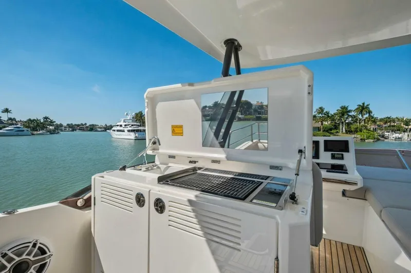 Slide: The Image of Luxury 2022 Prestige 520 yacht with outdoor grill and scenic waterfront view. - 72