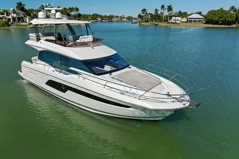 Slide: The Image of Luxury 2022 Prestige 520 yacht cruising in a serene, tropical waterway. - 8