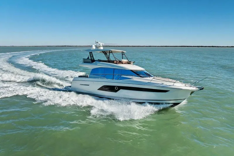 Slide: The Image of 2022 Prestige 520 yacht cruising on open water under clear blue skies. - 83