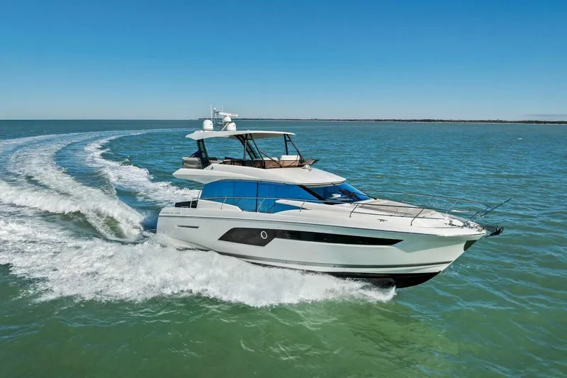 Slide: The Image of 2022 Prestige 520 yacht cruising on open water under clear blue skies. - 84