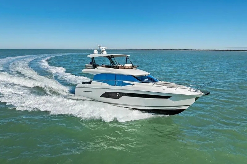 Slide: The Image of 2022 Prestige 520 yacht cruising on open water under clear blue skies. - 85