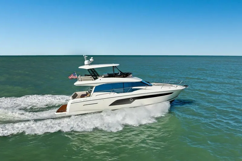 Slide: The Image of 2022 Prestige 520 yacht cruising on open water under clear blue sky. - 87