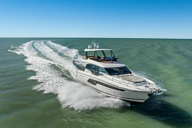 Slide: The Image of 2022 Prestige 520 yacht cruising on open sea under clear blue sky. - 88